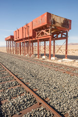 Fototapeta na wymiar Old Locomotive Watertanks by Railroad Track