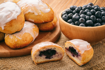 Sweet yeast buns with blueberries  on brown wooden table. 