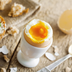 Perfect soft boiled egg and open bread sandwich with butter and dill on a table. Traditional food for healthy breakfast.