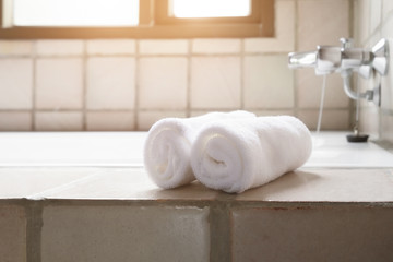 Fototapeta na wymiar White row of towels beside the bathtub in the bathroom.