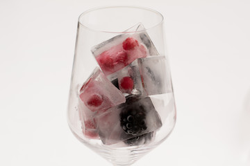 Glas of Ice Cubes with frozen Berries