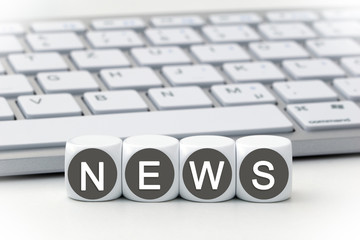 the word news on dices in front of a keyboard