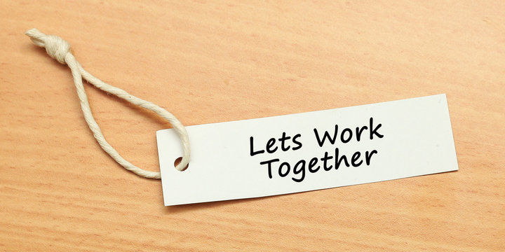 White Tag On Wooden Background With Word Quotes Of Lets Work Together