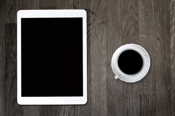 Fototapeta na wymiar Tablet pc looking like ipad on table with coffee cup