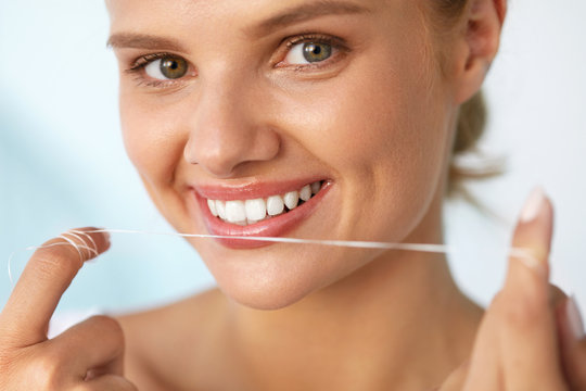 Dental Hygiene. Beautiful Woman Flossing Healthy White Teeth. High Resolution Image