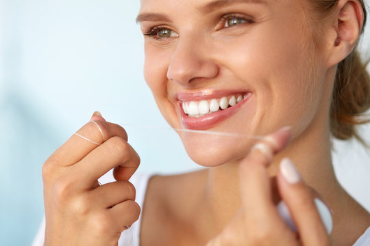 Dental Hygiene. Beautiful Woman Flossing Healthy White Teeth. High Resolution Image