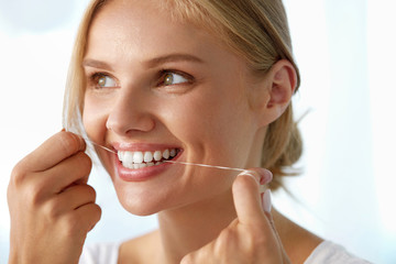 Teeth Care. Beautiful Smiling Woman Flossing Healthy White Teeth. High Resolution Image
