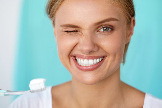 Woman With Beautiful Smile Brushing Healthy White Teeth. High Resolution Image
