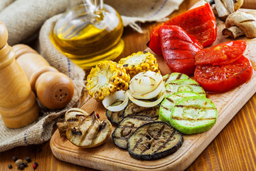 Fototapeta na wymiar Grilled vegetables: tomato, corn, eggplant, mushroom, bell pepper, marrow and onion. Delicious healthy food on a table. Close-up shot.