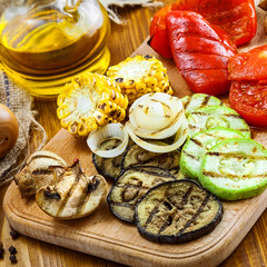 Set of grilled vegetables meal: tomato, corn, eggplant, mushroom, bell pepper, marrow and onion. Healthy organic food on a table.