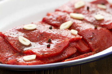 meat wuith sauce and garlic on white dish