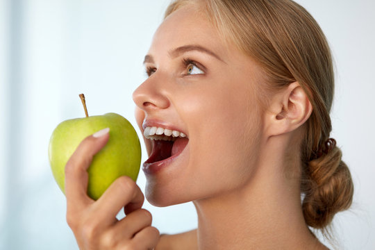 Woman Eating Apple. Beautiful Girl With White Teeth Biting Apple. High Resolution Image