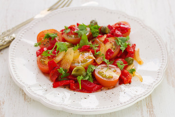 salad with tomato, red pepper and capers on plate