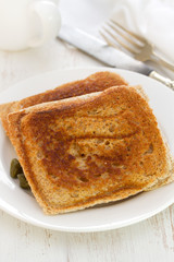 sandwiches on white plate on white wooden background