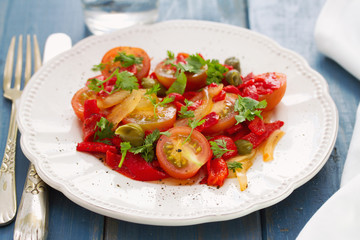 salad with tomato, red pepper and capers on plate