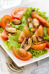 salad with tomato and mussels on white dish