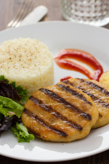 grilled meat with boiled rice and salad on white dish