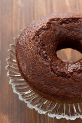chocolated cake on dish on brown wooden background