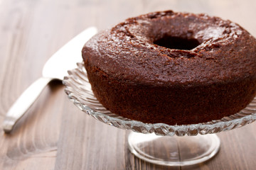 chocolated cake on dish on brown wooden background