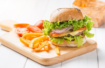 Delicious hamburger and french fries on wooden background