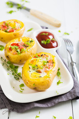 Potatoes stuffed with bacon, greens and eggs