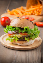 Delicious hamburger and french fries on wooden background