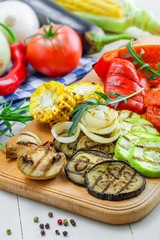 Grilled tomato, corn, eggplant, mushroom, bell pepper, marrow and onion on a table. Healthy prepared food with ingredients.