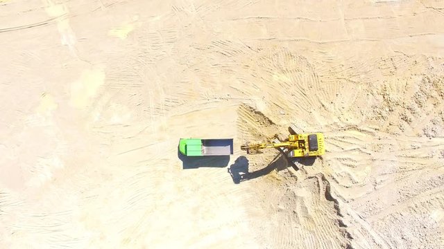 Camera flight over a working excavator in the mine. Industrial footage on mining theme. Heavy industry in Central Europe.