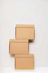 Three cardboard boxes on the white wooden floor