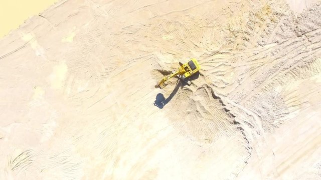 Camera flight over a working excavator in the mine. Industrial footage on mining theme. Heavy industry in Central Europe.