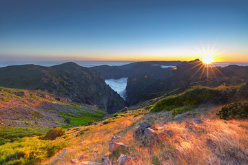 Obraz na płótnie Canvas Sunset over mountains of Madeira island above the clouds at Pico do Arieiro and Pico Ruivo
