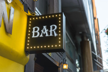 Vintage bar sign on a city street storefront.