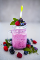 Delicious berry smoothy made with fresh ingredients on light background.