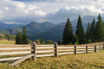 Summer landscape with a wooden fence in a mountain village