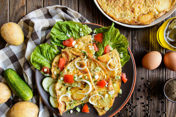 Typical Spanish tortilla - omelet with potatoes and onion with vegetable garnish
