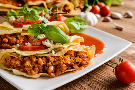 Pancakes stuffed with Bolognese filling - minced beef, pepper, onion, garlic and basil with tomato sauce