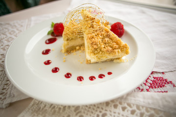 Slice of delicious cake on white plate with strawberries