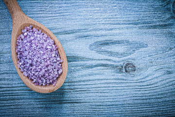 Lavender mineral crystal sea salt in wooden spoon on wood board 