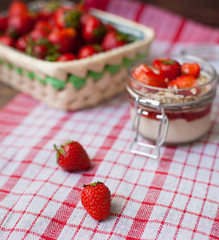 Fresh strawberries on the tablecloth and in the basket