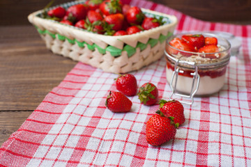 Fresh strawberries on the tablecloth and in the basket
