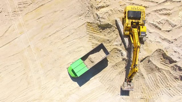 Camera flight over a working excavator in the mine. Industrial footage on mining theme. Heavy industry in Central Europe.