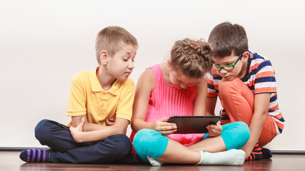 Kids playing on tablet.
