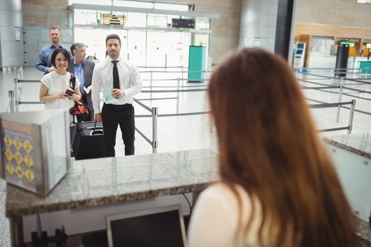 Passengers waiting in queue at check-in counter