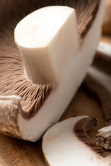 Fototapeta na wymiar sliced portobello mushroom, isolated on a cutting board, closeup, vertical