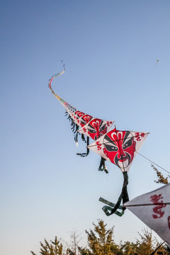 Row Of Chinese Paper Kites Flying On Clear Blue Sky