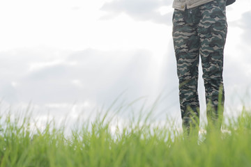Young woman in white dress walking on meadow with green grass