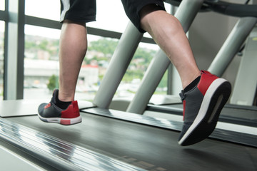 Fototapeta na wymiar Close-Up Man Feet On Treadmill