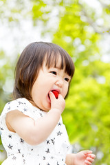 トマトを食べる幼い女の子