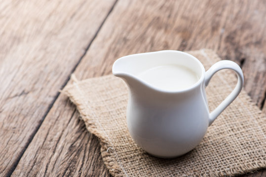 Milk in jug on wood table