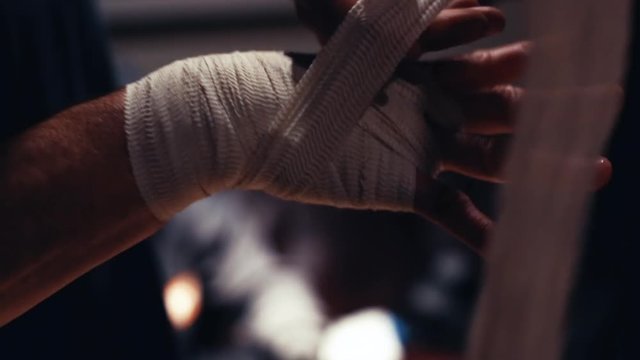 Boxing Trainer or Manager Wrapping Hands of a Boxer Close Up Shallow Depth of Field - Preparing For Boxing Match - Doctor Wrapping Possible Sprained or Broken Wrist of Injured Person